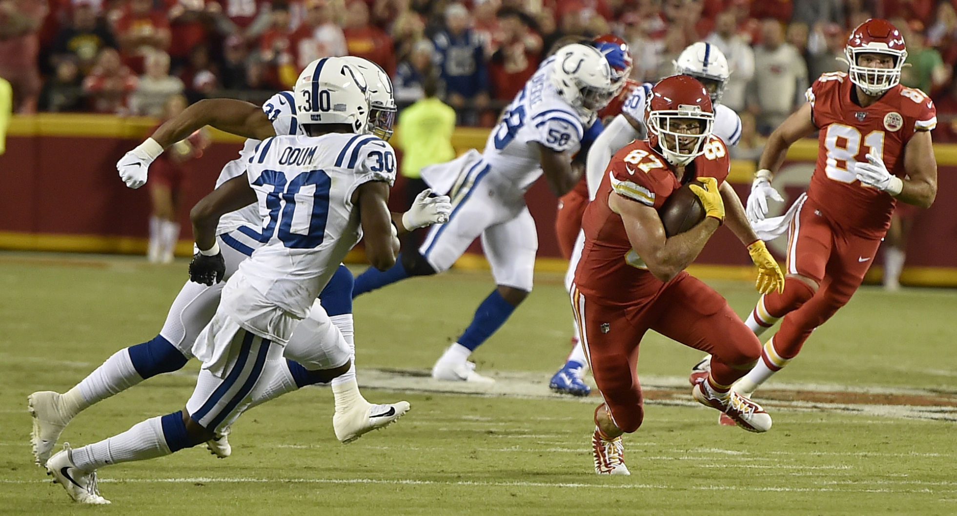 Kansas City Chiefs tight end Travis Kelce (87) turns up field as Indianapolis Colts defensive back George Odum (30) and Indianapolis Colts cornerback Quincy Wilson (31) pursue in the first half on Sunday, Oct. 6, 2019 at Arrowhead Stadium in Kansas City, Mo.